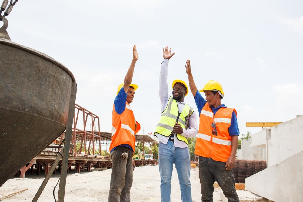 Hardworking construction team celebrating success on a building site.