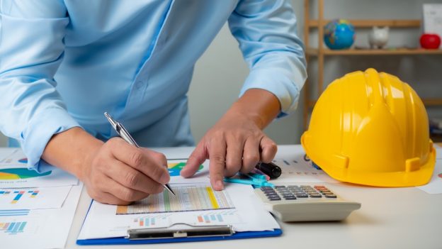 Construction planning with safety gear and blueprints for prospective contractors.