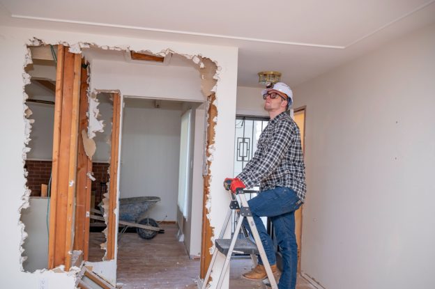Construction worker inspecting a home renovation project, emphasizing skill development in the contractor industry.