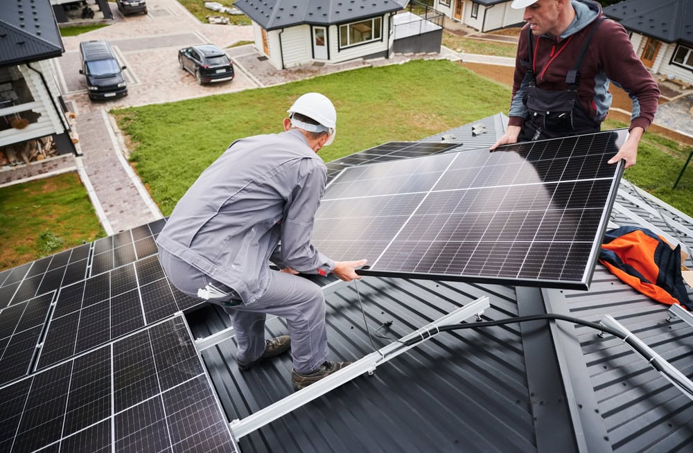 Solar panel installation on a residential roof by professional contractors in progress.