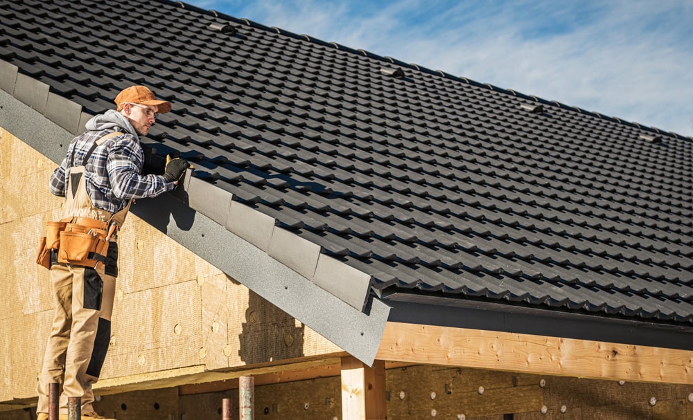 Roofing contractor inspecting roof installation on a residential building.