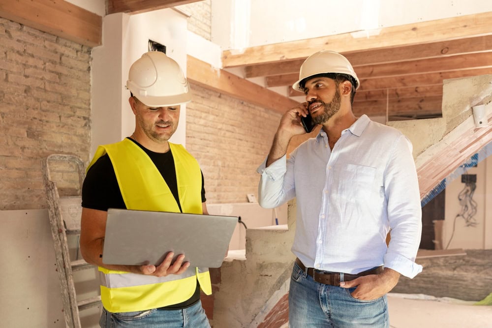 Construction workers discussing project details inside a building site.