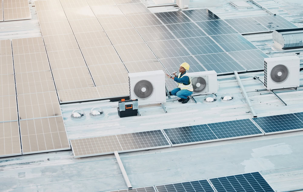 Technician installing or maintaining solar panels and HVAC units on a commercial building roof, emphasizing renewable energy and HVAC system expertise.